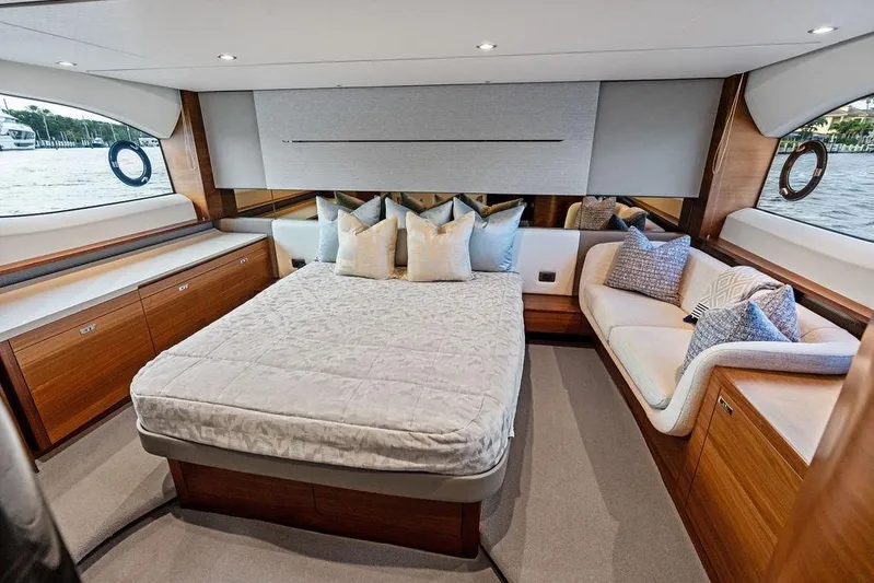 Hullabaloo Yacht Photos Pics Luxurious 2021 Princess V55 yacht bedroom with elegant wood finishes and plush bedding.