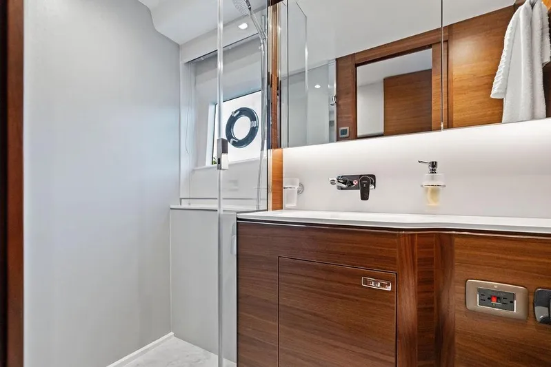 Hullabaloo Yacht Photos Pics Luxurious bathroom interior of 2021 Princess V55 yacht with modern wood finishes.