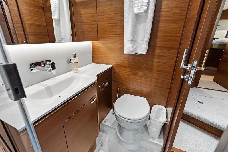 Hullabaloo Yacht Photos Pics Luxurious bathroom in 2021 Princess V55 yacht with modern fixtures and wooden cabinetry.