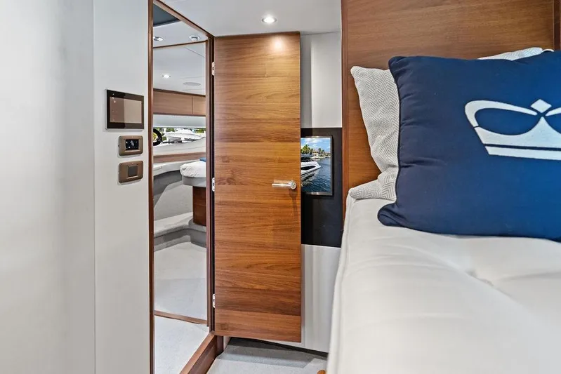 Hullabaloo Yacht Photos Pics Interior of 2021 Princess V55 yacht with modern wood finish and cozy bedding.