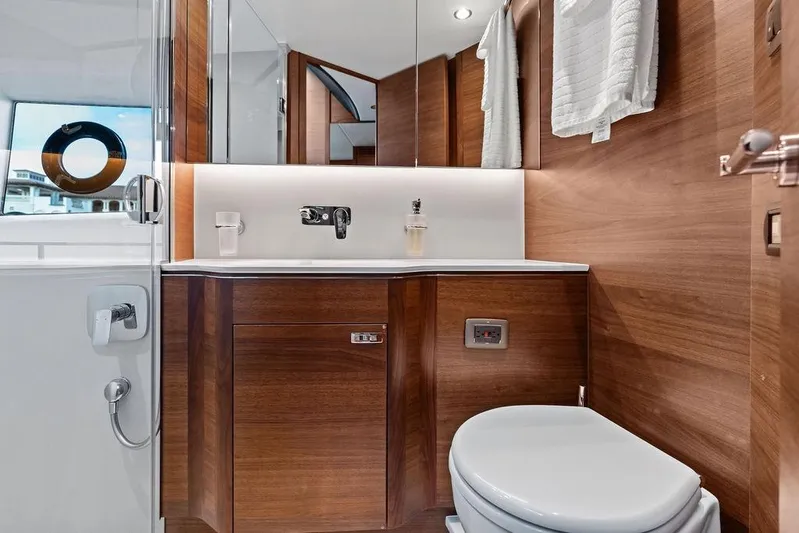 Hullabaloo Yacht Photos Pics Luxurious bathroom in 2021 Princess V55 yacht with wood accents and modern fixtures.