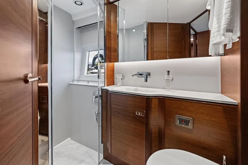 Hullabaloo Yacht Photos Pics Luxurious bathroom in 2021 Princess V55 yacht with modern wood finishes and sleek fixtures.