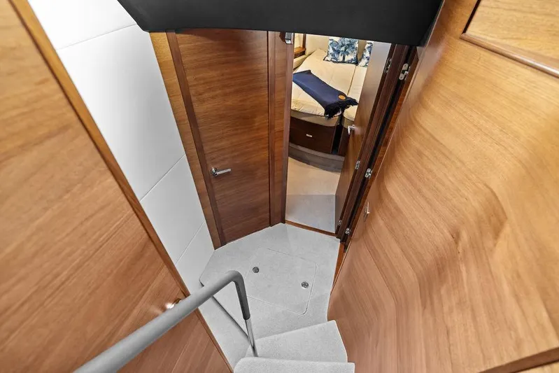 Hullabaloo Yacht Photos Pics Interior view of 2021 Princess V55 yacht, featuring wooden doors and cozy cabin space.
