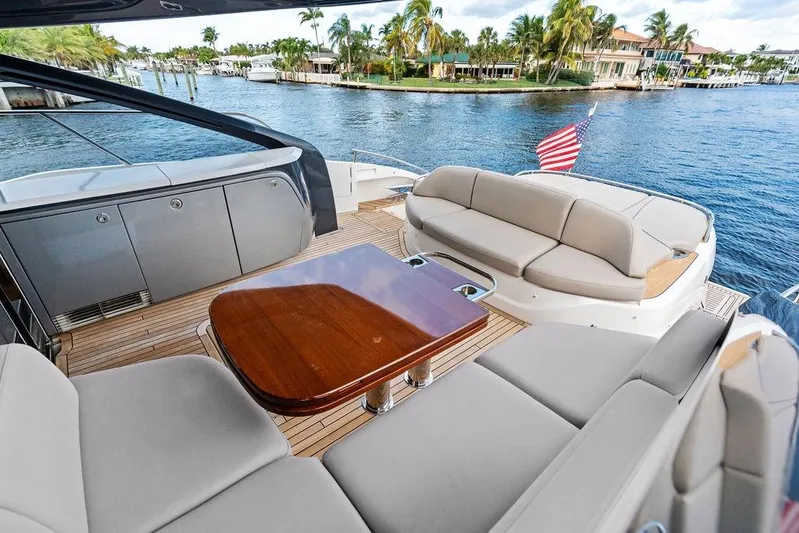 Hullabaloo Yacht Photos Pics Luxurious 2021 Princess V55 yacht deck with elegant seating and scenic waterfront view.