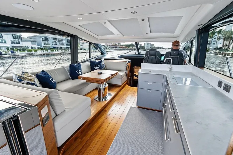 Hullabaloo Yacht Photos Pics Luxurious interior of 2021 Princess V55 yacht with modern seating and sleek kitchen area.