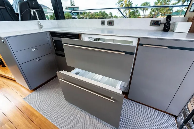 Hullabaloo Yacht Photos Pics Modern kitchen on 2021 Princess V55 yacht with sleek cabinetry and open drawers.