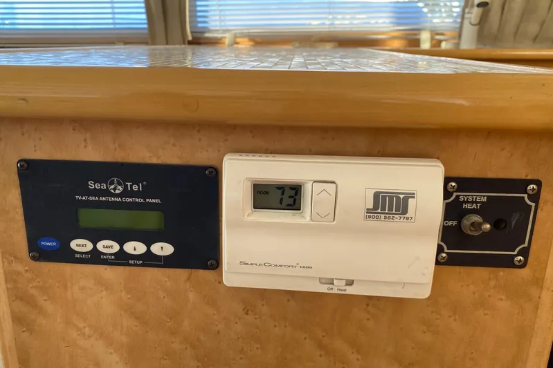 Coldwater Fusion Yacht Photos Pics Control panels on a 1998 Navigator 5300 Classic yacht, featuring Sea Tel and thermostat systems.