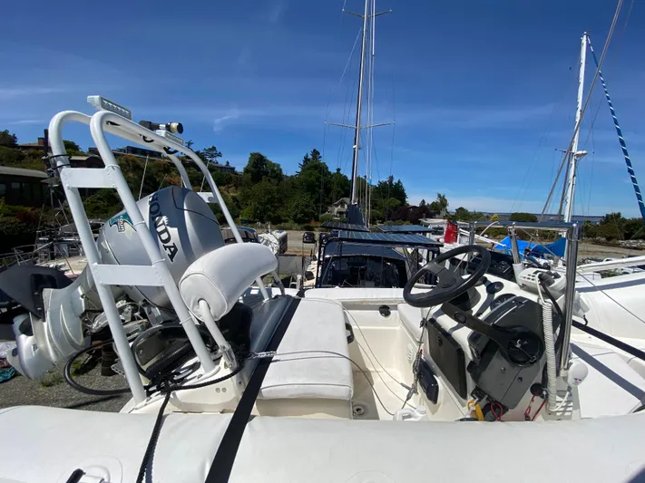 Coldwater Fusion Yacht Photos Pics 1998 Navigator 5300 Classic tender with Honda outboard motor, docked under clear blue sky.