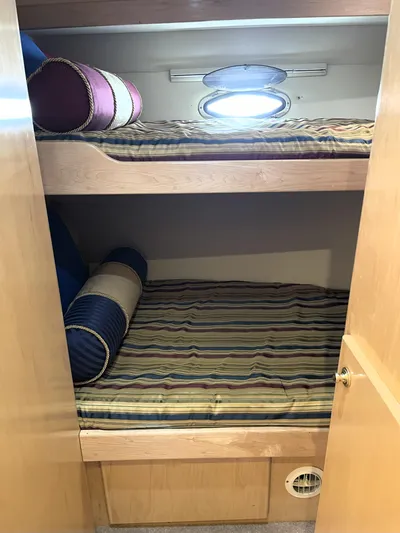 Coldwater Fusion Yacht Photos Pics Bunk beds in 1998 Navigator 5300 Classic yacht cabin with striped bedding and porthole window.