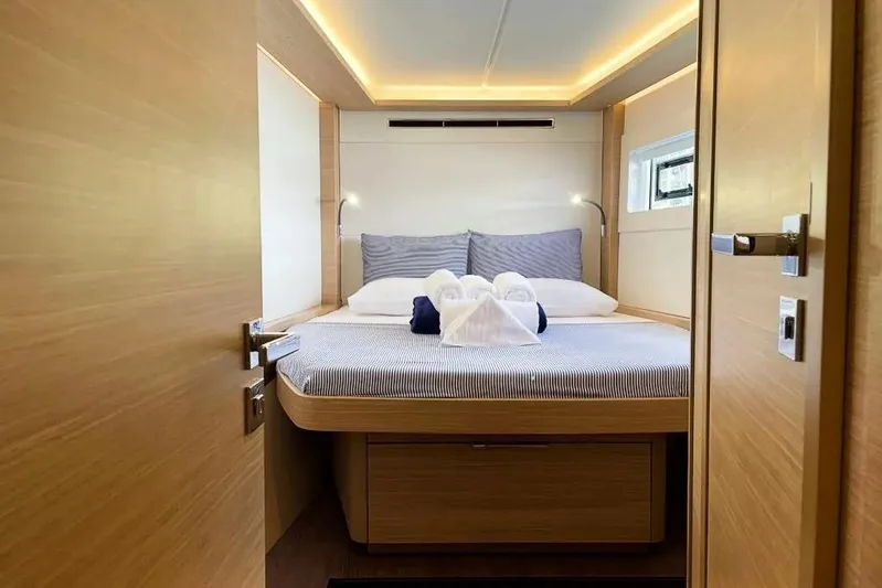 Artemis Yacht Photos Pics Luxurious bedroom interior of 2023 Lagoon 46 yacht with elegant lighting and cozy bedding.