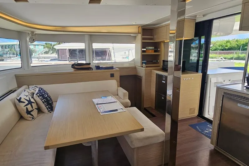 Artemis Yacht Photos Pics Modern interior of 2023 Lagoon 46 yacht with dining area and kitchen amenities.