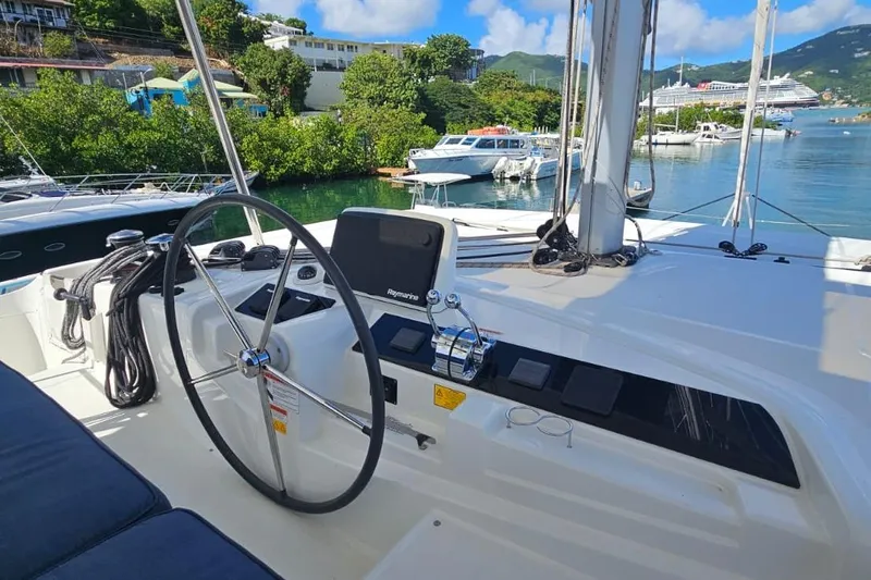 Artemis Yacht Photos Pics 2023 Lagoon 46 yacht helm with scenic marina view, featuring modern navigation equipment.