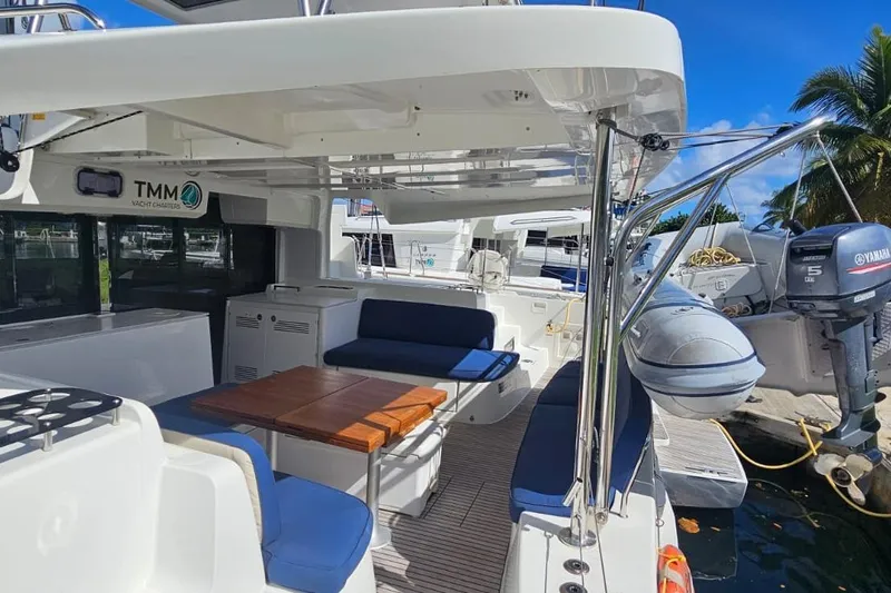 Artemis Yacht Photos Pics 2023 Lagoon 46 yacht with outdoor seating and Yamaha motor, docked under clear skies.