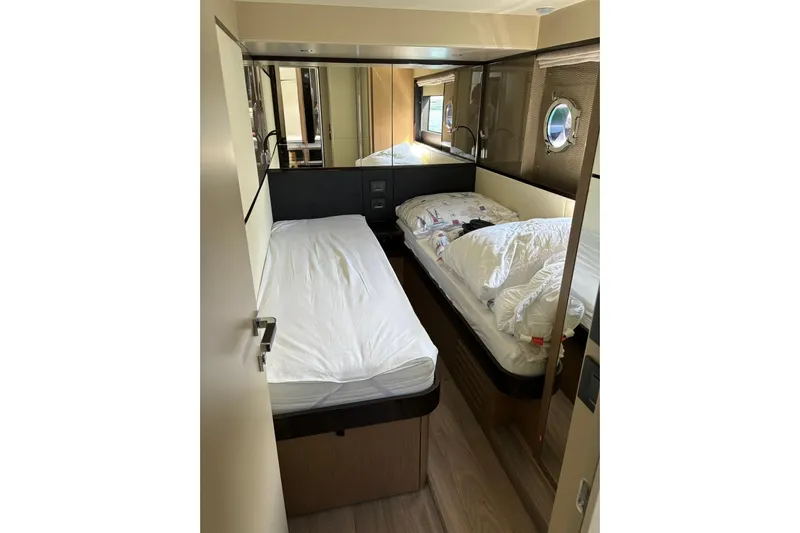  Yacht Photos Pics 2024 Absolute 60 Fly yacht cabin with twin beds and porthole window.