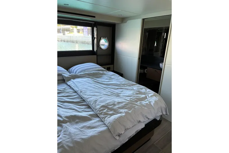  Yacht Photos Pics Luxurious bedroom interior of 2024 Absolute 60 Fly yacht with window view.