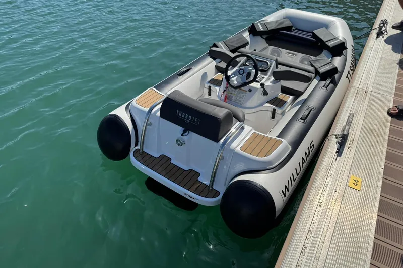  Yacht Photos Pics 2024 Absolute 60 Fly yacht docked, featuring Williams Turbojet 325 tender on calm water.