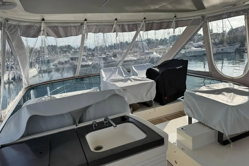  Yacht Photos Pics 2024 Absolute 60 Fly yacht interior with covered seating and marina view.