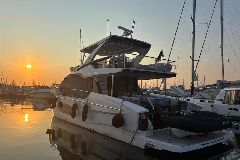  Yacht Photos Pics 2024 Absolute 60 Fly yacht docked at sunset, reflecting on calm water.