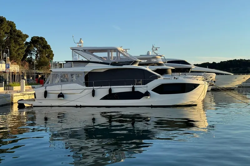  Yacht Photos Pics 2024 Absolute 60 Fly yacht docked in a serene marina setting.