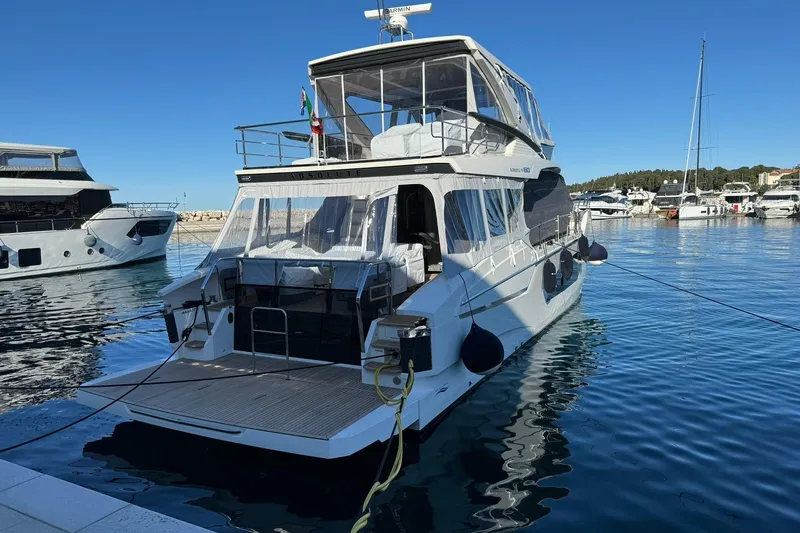  Yacht Photos Pics 2024 Absolute 60 Fly yacht docked in a marina under clear blue skies.