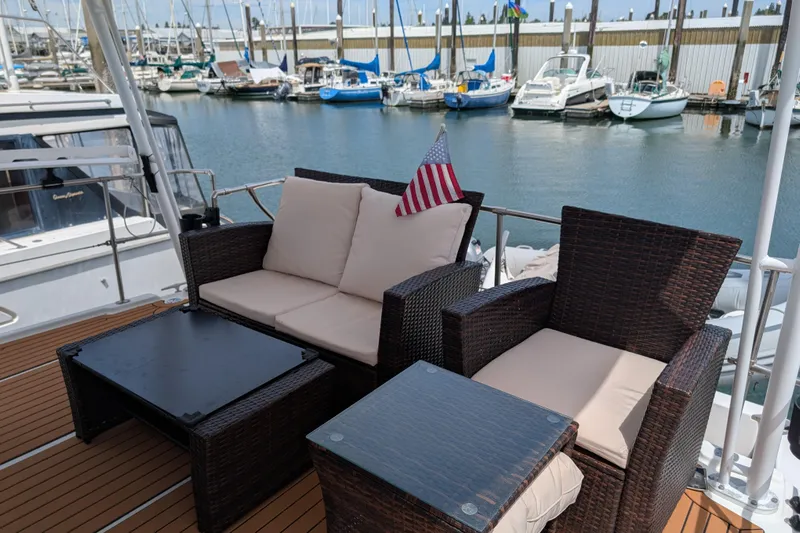 Elena Yacht Photos Pics Outdoor seating on 2000 Bayliner 4088 yacht, docked at marina with boats in background.