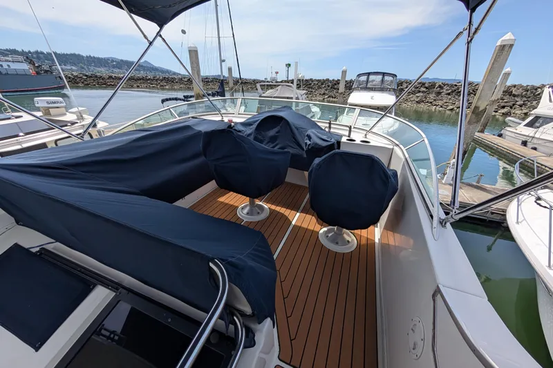 Elena Yacht Photos Pics Bayliner 4088 yacht, 2000 model, docked with covered seating and wooden deck.