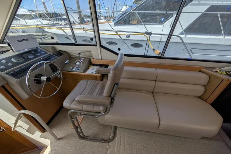 Elena Yacht Photos Pics Interior of 2000 Bayliner 4088 yacht with steering wheel and beige seating.
