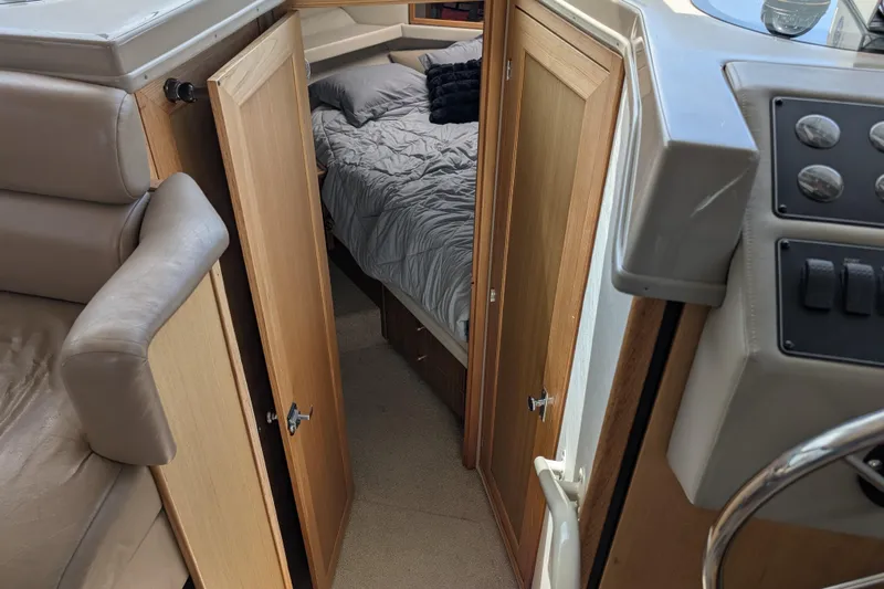 Elena Yacht Photos Pics Interior of 2000 Bayliner 4088 yacht showing cabin with bed and wooden doors.