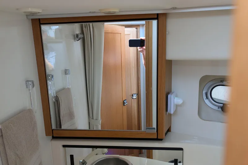 Elena Yacht Photos Pics Bathroom interior of 2000 Bayliner 4088 yacht with mirror and porthole.