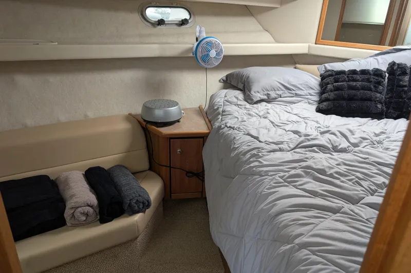 Elena Yacht Photos Pics Cozy bedroom in 2000 Bayliner 4088 yacht with bed, fan, and folded towels.