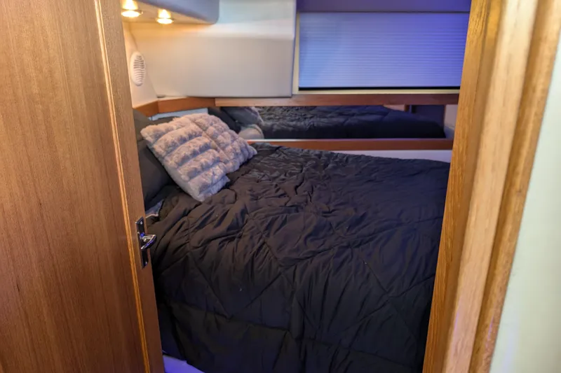 Elena Yacht Photos Pics Cozy bedroom in 2000 Bayliner 4088 yacht with plush bedding and ambient lighting.