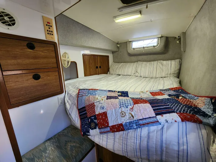  Yacht Photos Pics Cozy cabin interior of 2000 Manta 42 sailboat with bed and patchwork quilt.