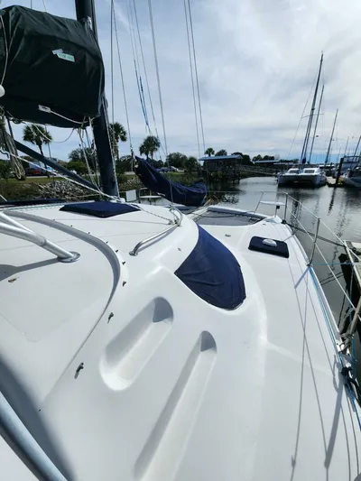  Yacht Photos Pics Sailboat Manta 42, 2000 model, docked in a marina with clear skies.