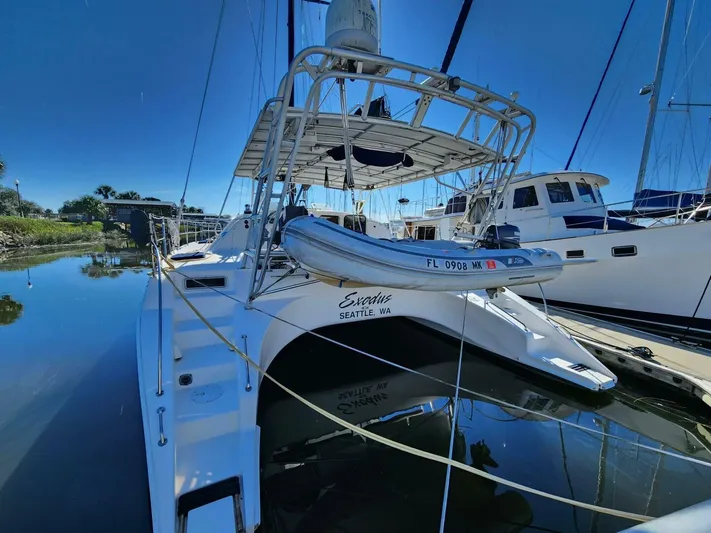  Yacht Photos Pics Manta 42 catamaran from 2000 docked in a marina, reflecting on calm water.