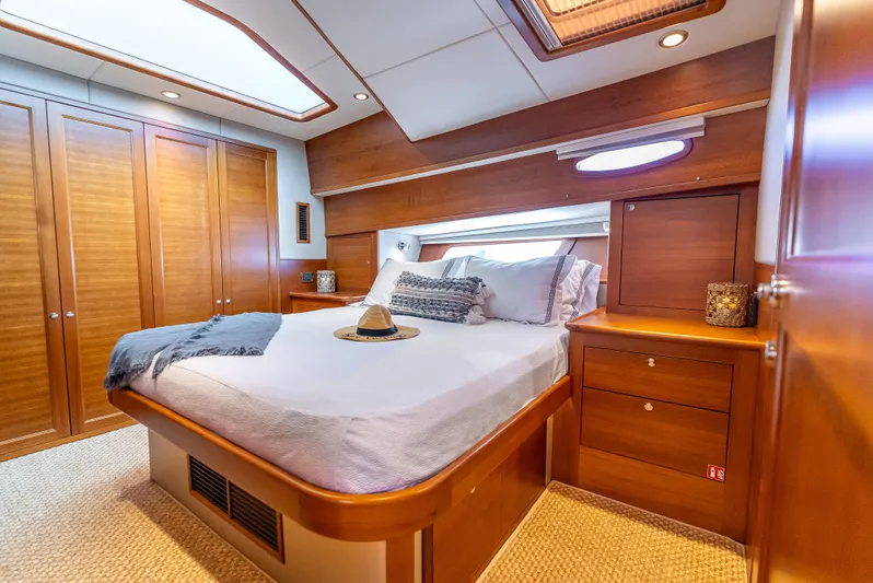 Tonic Yacht Photos Pics Luxurious 2018 Grand Banks GB60 yacht bedroom with elegant wood finishes and cozy bedding.