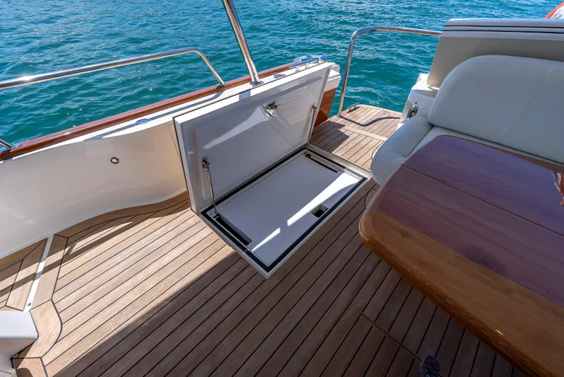 Tonic Yacht Photos Pics 2018 Grand Banks GB60 yacht deck with open storage compartment and elegant wood finish.