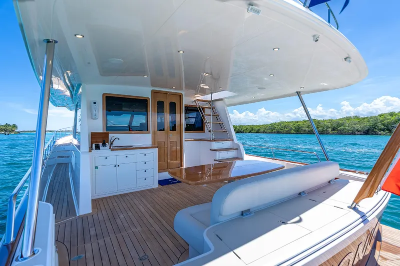 Tonic Yacht Photos Pics Luxurious 2018 Grand Banks GB60 yacht deck with seating, table, and ocean view.