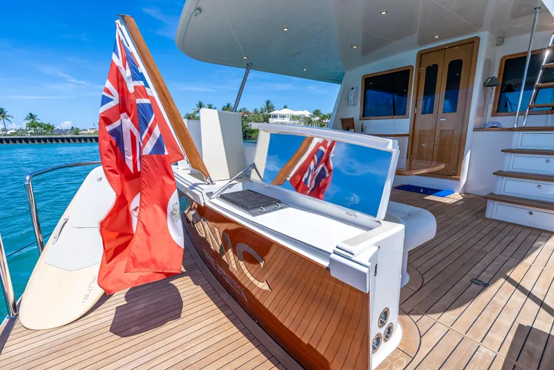 Tonic Yacht Photos Pics 2018 Grand Banks GB60 yacht deck with flag, TV, and ocean view.