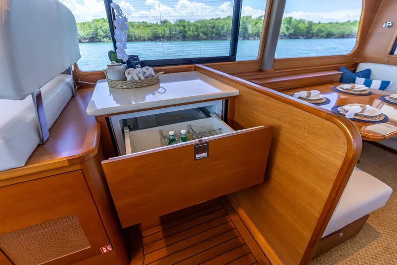 Tonic Yacht Photos Pics Luxurious 2018 Grand Banks GB60 yacht interior with open drawer fridge and elegant dining setup.
