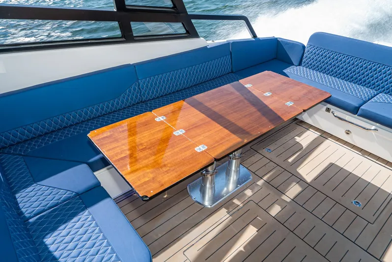 On Its Way Yacht Photos Pics 2024 Bavaria Vida 33 boat interior with blue seating and wooden table.