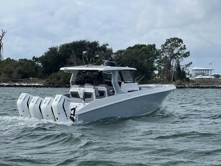  Yacht Photos Pics 2024 Fountain 38 SCX boat cruising on water with triple outboard engines.