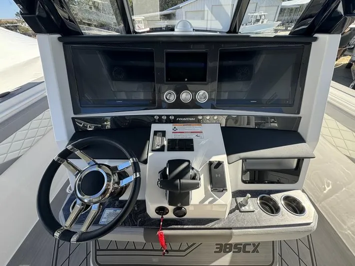  Yacht Photos Pics 2024 Fountain 38 SCX boat dashboard with steering wheel and control panel.