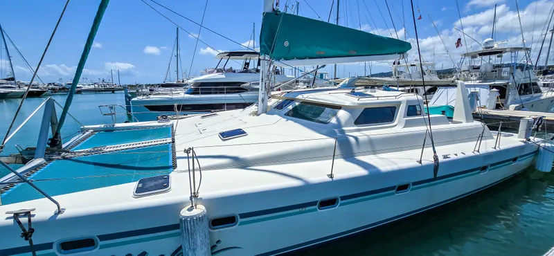 Makai Yacht Photos Pics 1997 Voyage Mayotte 50 catamaran docked in a marina under clear blue skies.