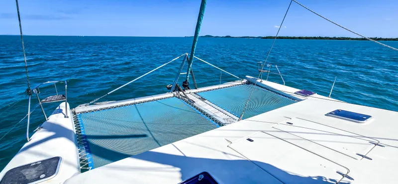 Makai Yacht Photos Pics Catamaran deck on Voyage Mayotte 50, 1997, sailing in clear blue ocean waters.