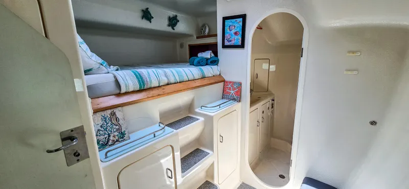 Makai Yacht Photos Pics Interior of 1997 Voyage Mayotte 50 yacht with cozy bed and compact bathroom.