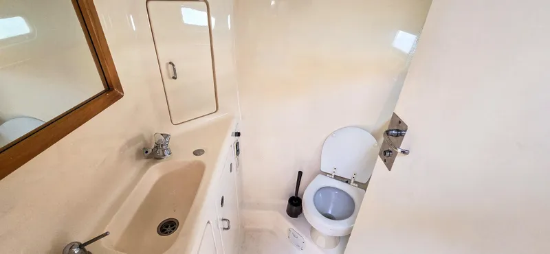 Makai Yacht Photos Pics Compact bathroom in 1997 Voyage Mayotte 50 yacht with sink and toilet.