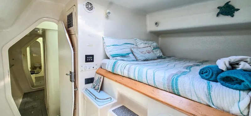 Makai Yacht Photos Pics Cozy cabin interior of 1997 Voyage Mayotte 50 yacht with bed and bathroom.