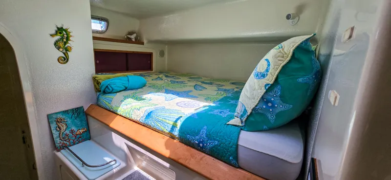 Makai Yacht Photos Pics Cozy cabin interior of 1997 Voyage Mayotte 50 with vibrant bedding and nautical decor.