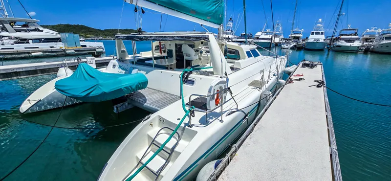 Makai Yacht Photos Pics Catamaran Voyage Mayotte 50, 1997 model, docked in a marina with clear blue skies.