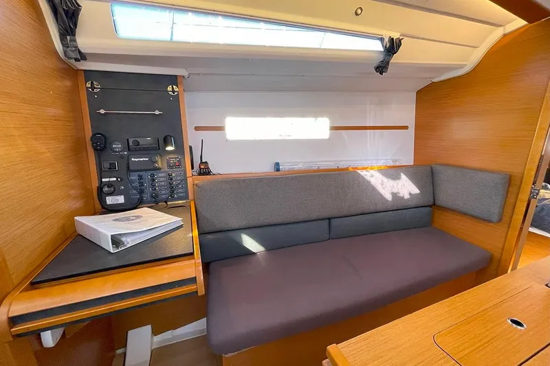 Imagine Yacht Photos Pics Interior of 2017 Jeanneau Sun Odyssey 349 sailboat with navigation station and seating area.